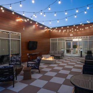 Cozy outdoor patio with string lights and a fire pit.