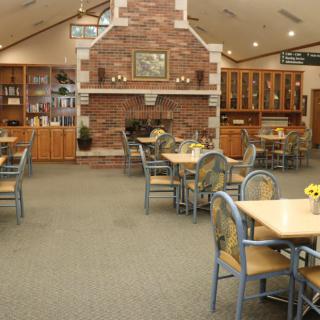 A cozy dining area featuring a brick fireplace and neatly arranged tables and chairs.