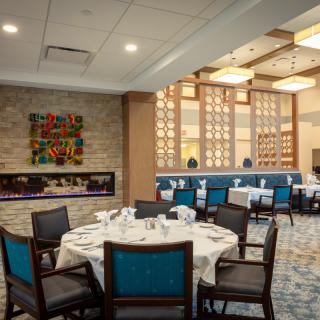 A stylish restaurant dining area with neatly set tables, elegant decor, and warm lighting.