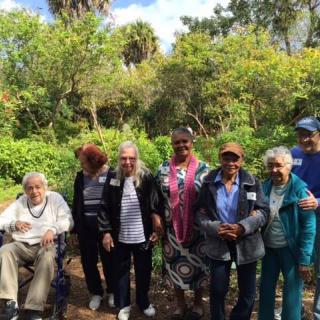 A group of people posing together in a lush garden setting.