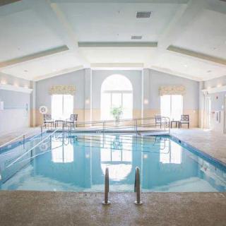 A tranquil indoor swimming pool area with large windows and ample natural light.
