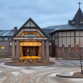 A church building with illuminated entrance in the evening.