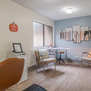 A cozy waiting room with modern furniture and decorative artwork on the wall.