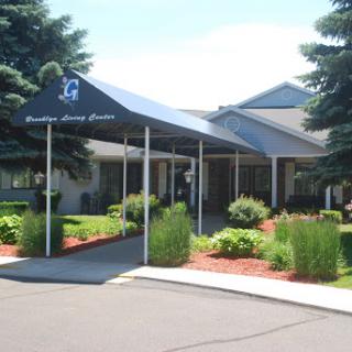 The welcoming entrance of a modern facility, surrounded by lush landscaping.