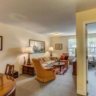 A cozy living room with comfortable seating, decorative artwork, and warm lighting.