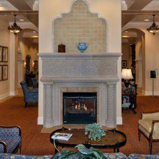 A cozy lounge area featuring a stylish fireplace, comfortable seating, and elegant decor.