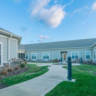 A well-maintained residential building with a paved pathway and landscaped surroundings.