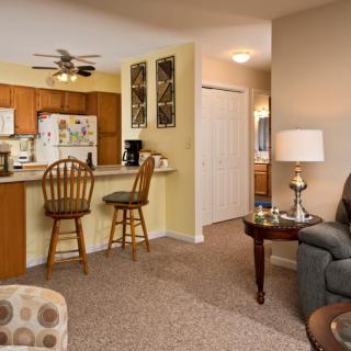 A cozy living area with a view of the kitchen and bar stools.