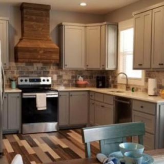 A modern kitchen with wooden cabinets and a stylish range hood.