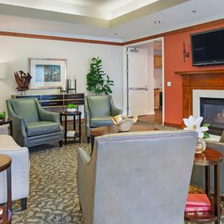 A cozy living room with comfortable seating, a fireplace, and a television.