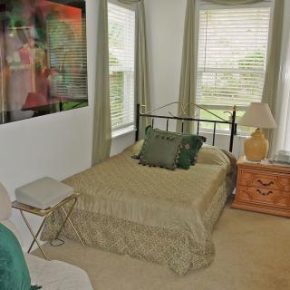 A cozy bedroom with a bed, side table, and decor items.