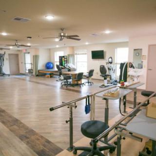 A spacious rehabilitation center equipped with various exercise machines and therapy tools.