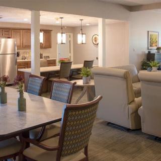 A modern open floor plan featuring a comfortable living room, a dining area with stylish chairs, and a kitchen equipped with stainless steel appliances.