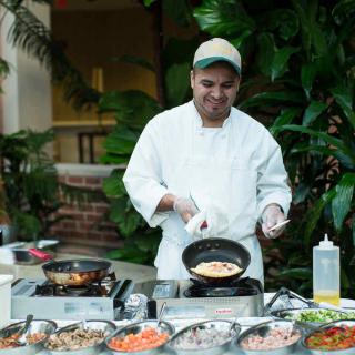 A chef preparing dishes at an outdoor cooking station.