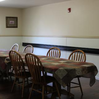 A simple dining area with a long table and wooden chairs, perfect for gatherings.