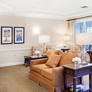 A cozy and elegantly decorated living room with a comfortable sofa, lamps, and framed artwork.