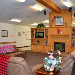 A cozy living room featuring a fireplace, television, and comfortable seating with decorative elements.
