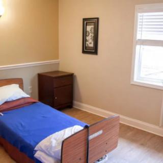 A minimalist bedroom with a single bed and wooden furniture.