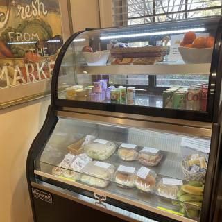 A display case filled with a variety of sandwiches and deli items inside a market.
