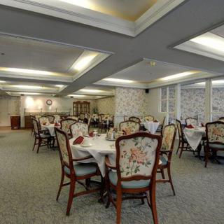 An elegant dining room with beautifully decorated tables and chairs, set in a refined interior.
