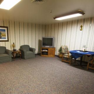 A cozy living room with armchairs, a television, and a small table.