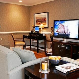 A cozy living room with a television, desk, and comfortable seating.