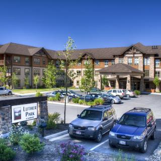 A modern hotel surrounded by lush greenery and a clear blue sky.