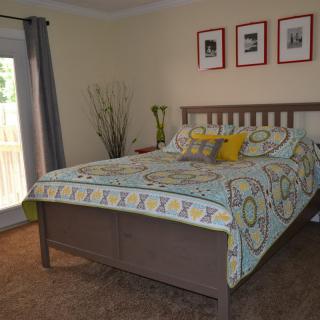 A cozy bedroom with a neatly made bed and decorative pillows.