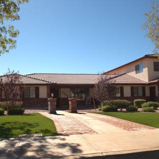 A suburban house with a well-maintained lawn and a driveway on a sunny day.