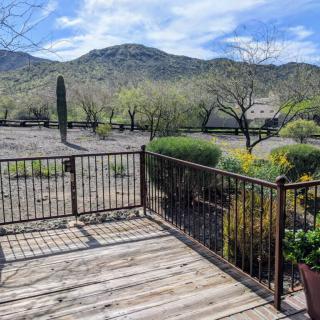 A wooden deck overlooking a scenic view of mountains and trees.