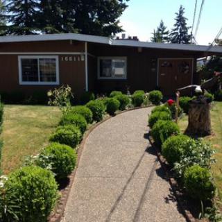 A charming home with a well-kept garden and a winding pathway.