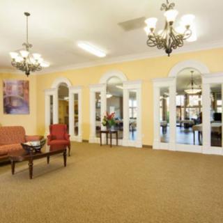 A spacious lobby with elegant chandeliers, comfortable seating, and large mirrors reflecting the interior.