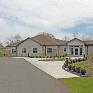A modern residential building with a well-designed landscape and driveway.