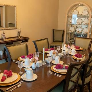 A formal dining room setup with a well-arranged table ready for a meal.