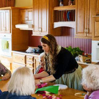 A group of people engaged in a crafting activity in a kitchen setting.