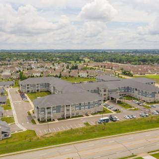 Aerial view of a suburban housing complex with parking areas and surrounding neighborhood.