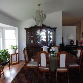 A dining room featuring a chandelier, dining table with chairs, and a china cabinet.