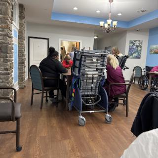 A gathering of individuals at a dining area in an elderly care facility.
