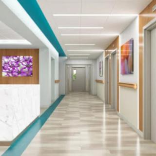 A modern and clean hospital corridor with colorful artwork on the walls.