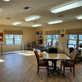 A bright and spacious rehabilitation room equipped for group activities and therapy.