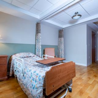 A serene hospital room equipped with a patient bed and a cozy atmosphere.