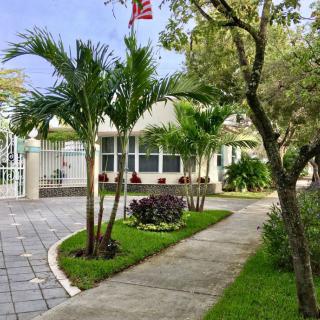 A well-maintained house with palm trees and a landscaped driveway.
