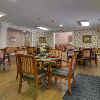 A cozy dining area featuring wooden tables and chairs with decorative wallpaper.