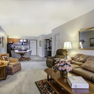 A cozy living room with plush sofas and a coffee table, adjacent to a dining area.