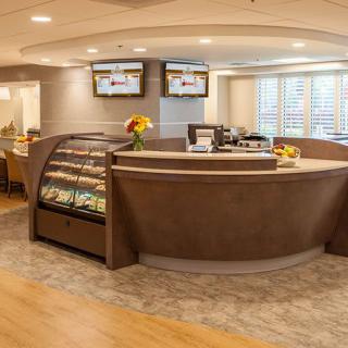 A modern cafe interior with a central counter and seating area.