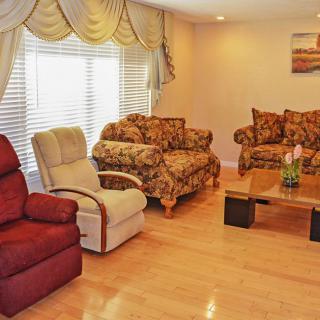A cozy living room with patterned sofas, armchairs, and a wooden coffee table.