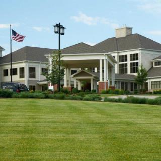 A large building with a well-maintained lawn, featuring an American flag.