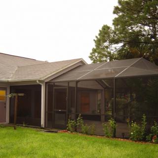 A house with a screened porch in the backyard.