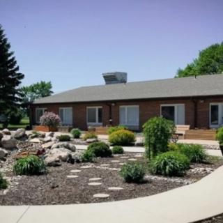 A landscaped garden surrounds a single-story building with a curved pathway.
