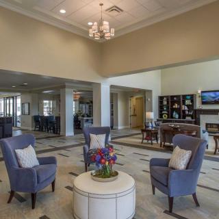 A spacious lobby with elegant furniture and a chandelier.